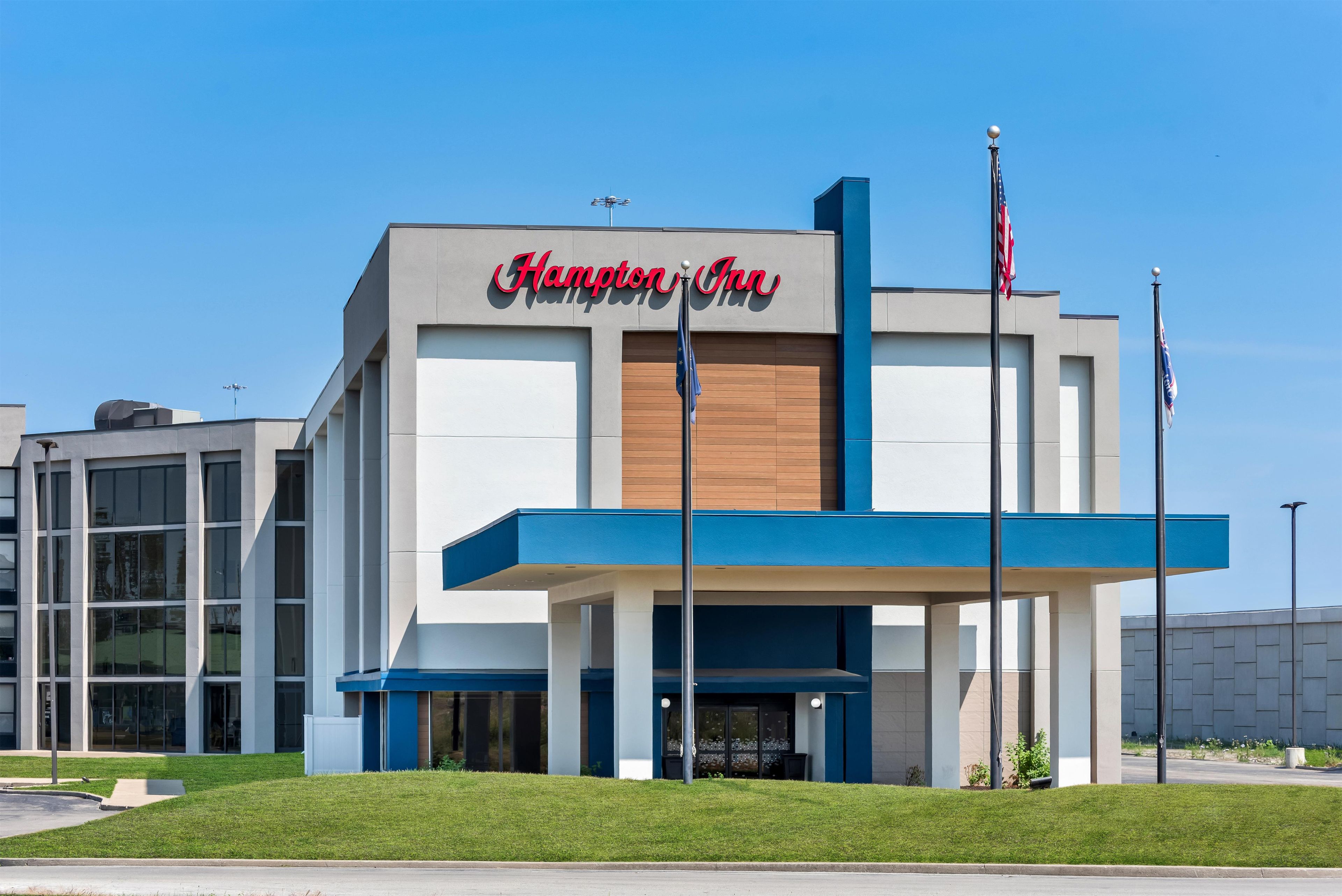 Ein Hampton Inn Hotel mit moderner Fassade, großen Fenstern und auffälliger Beschilderung.