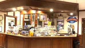 A breakfast counter with various food items and a coffee machine. - Baymont by Wyndham Front Royal Near Shenandoah National Park (Front Royal)