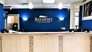 A Baymont Inn & Suites reception desk with a blue wall, two overhead lights, and a Dell computer. - Baymont by Wyndham Front Royal Near Shenandoah National Park (Front Royal)