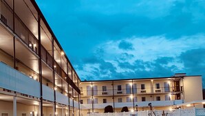 A multi-story hotel with a courtyard, outdoor seating, and a guest parking area. - Baymont by Wyndham Front Royal Near Shenandoah National Park (Front Royal)
