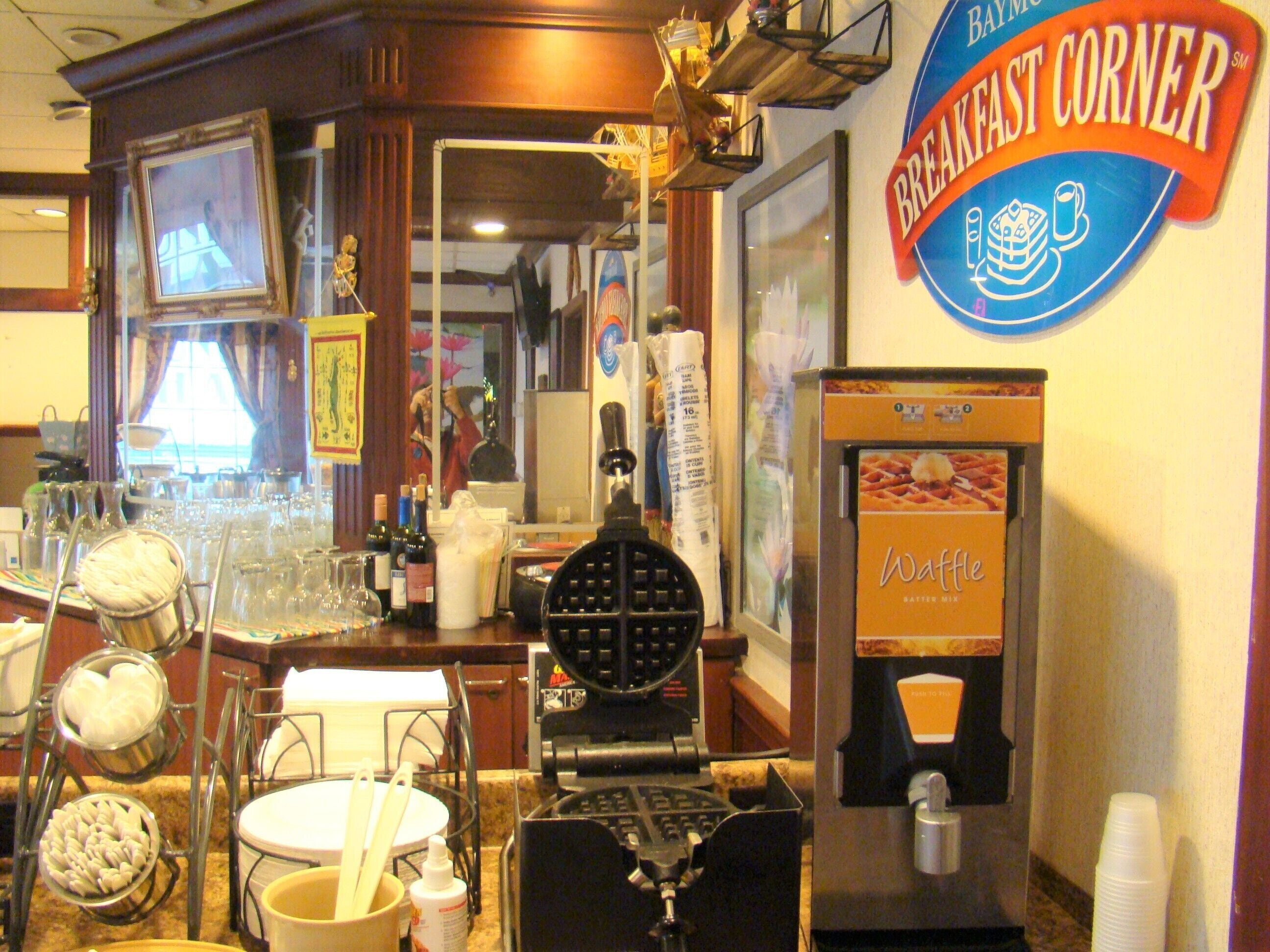 A breakfast corner with a waffle maker, a coffee machine, and various kitchen utensils.
