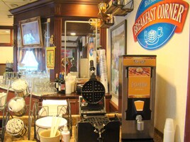A breakfast corner with a waffle maker, a coffee machine, and various kitchen utensils.