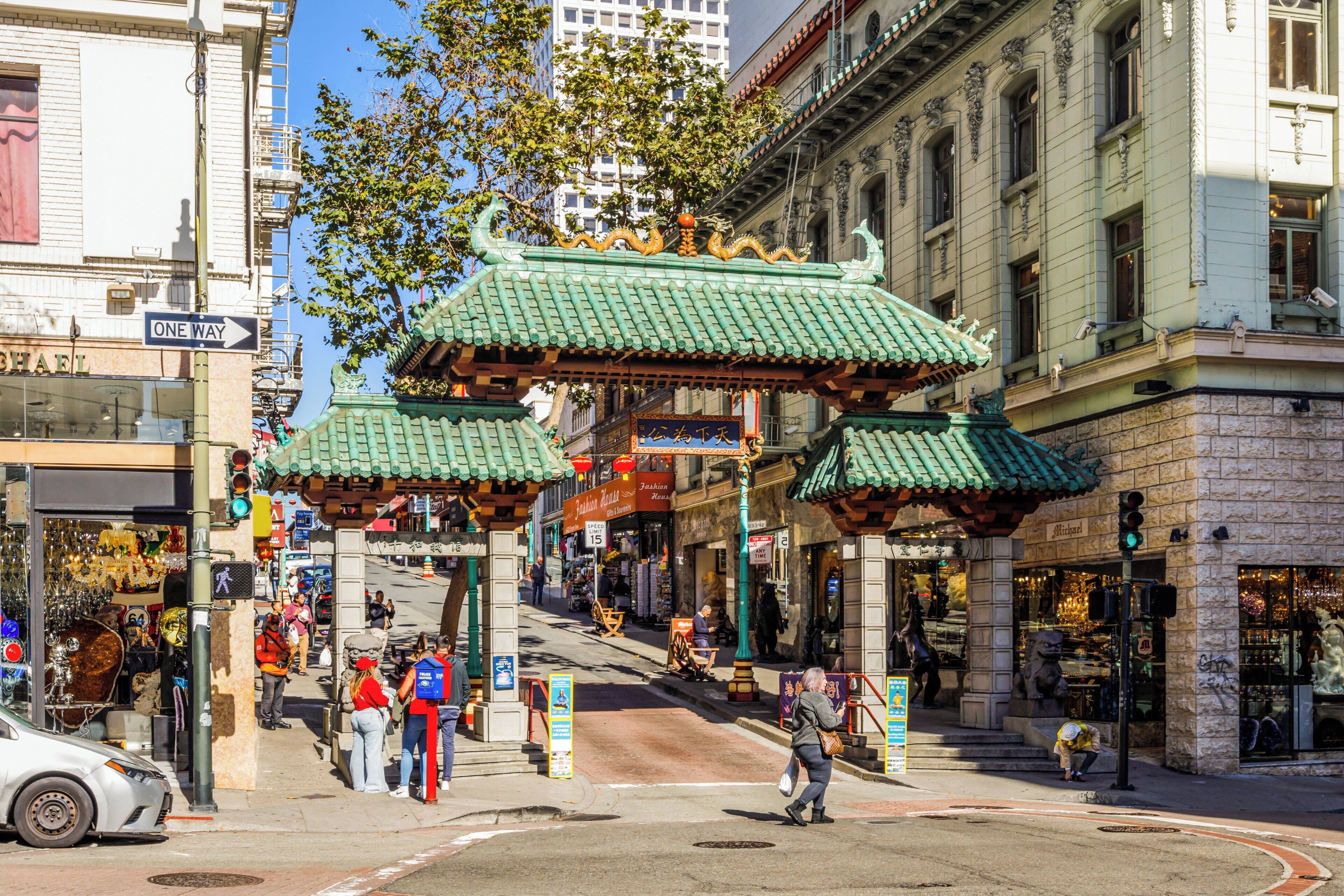 A street with traditional Asian architecture, including green-roofed buildings and ornate decorations.