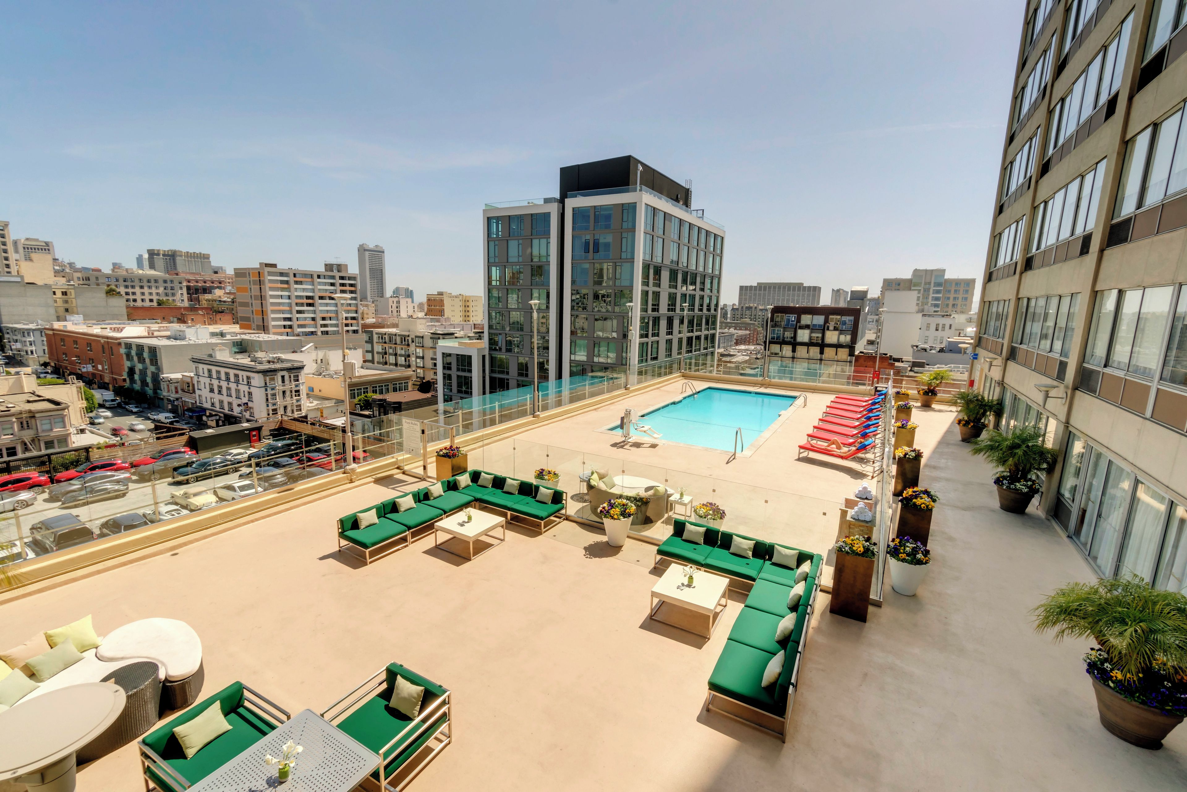 A rooftop pool area with lounge chairs and a pool.