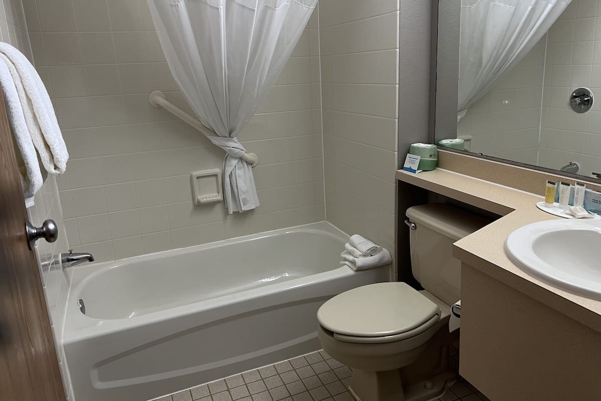 A bathroom with a bathtub, toilet, and sink.