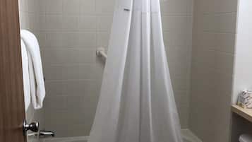 Un baño con bañera, inodoro y cortina de ducha.