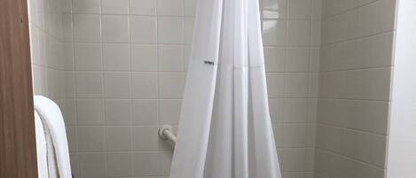 A bathroom with a bathtub, toilet, and a shower curtain.