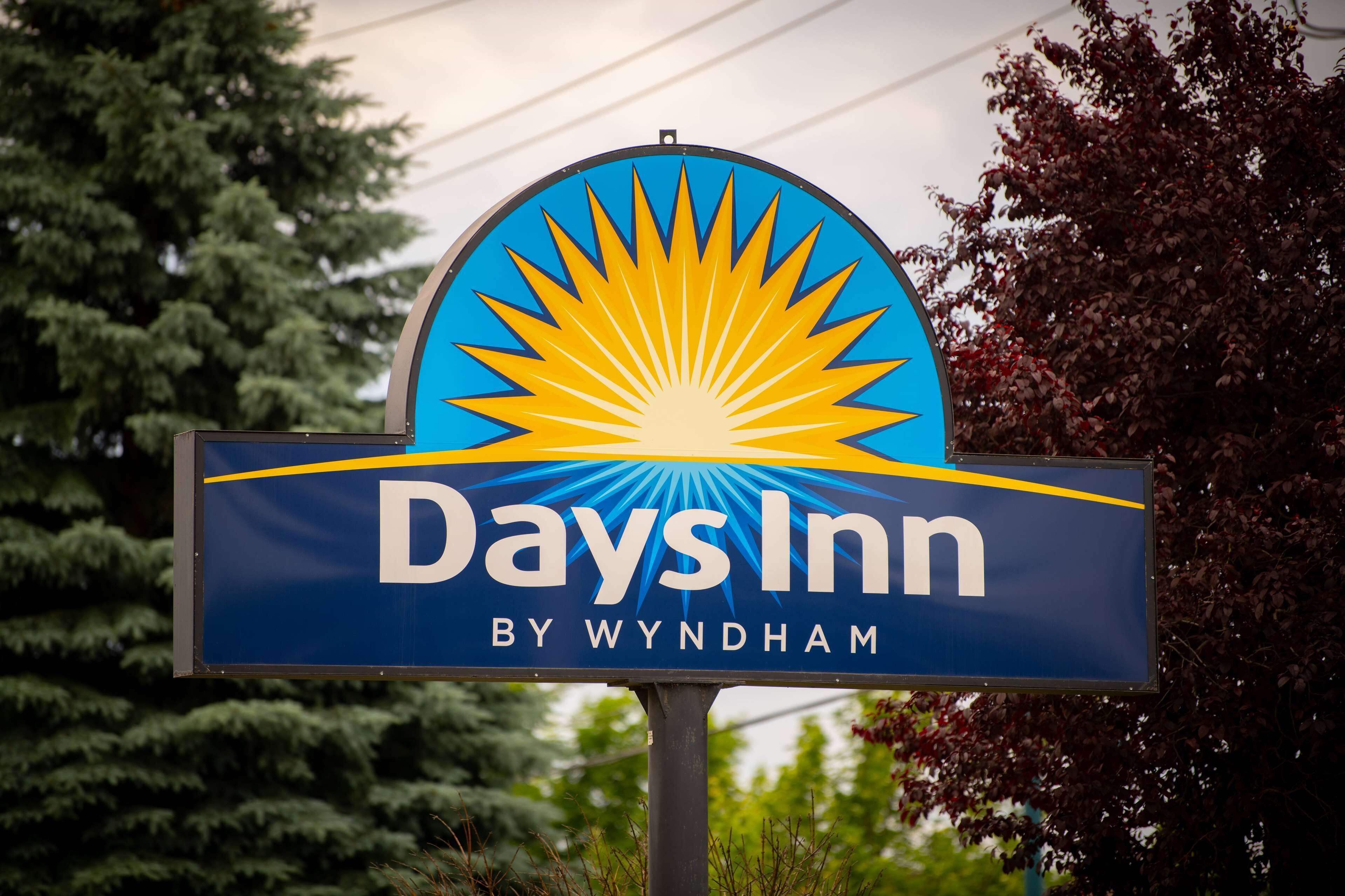 Señal de Days Inn con un diseño de explosión solar y el nombre 'Days Inn by Wyndham'.