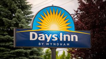 Señal de Days Inn con un diseño de explosión solar y el nombre 'Days Inn by Wyndham'.