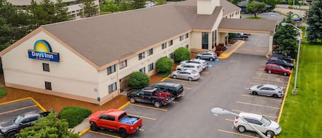 Un hotel Days Inn con un estacionamiento que contiene varios coches y una camioneta roja.