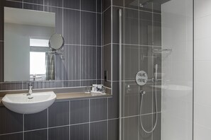 Suite Junior, 1 très grand lit et 1 canapé-lit | Salle de bain | Ensemble baignoire-douche, articles de toilette écologiques