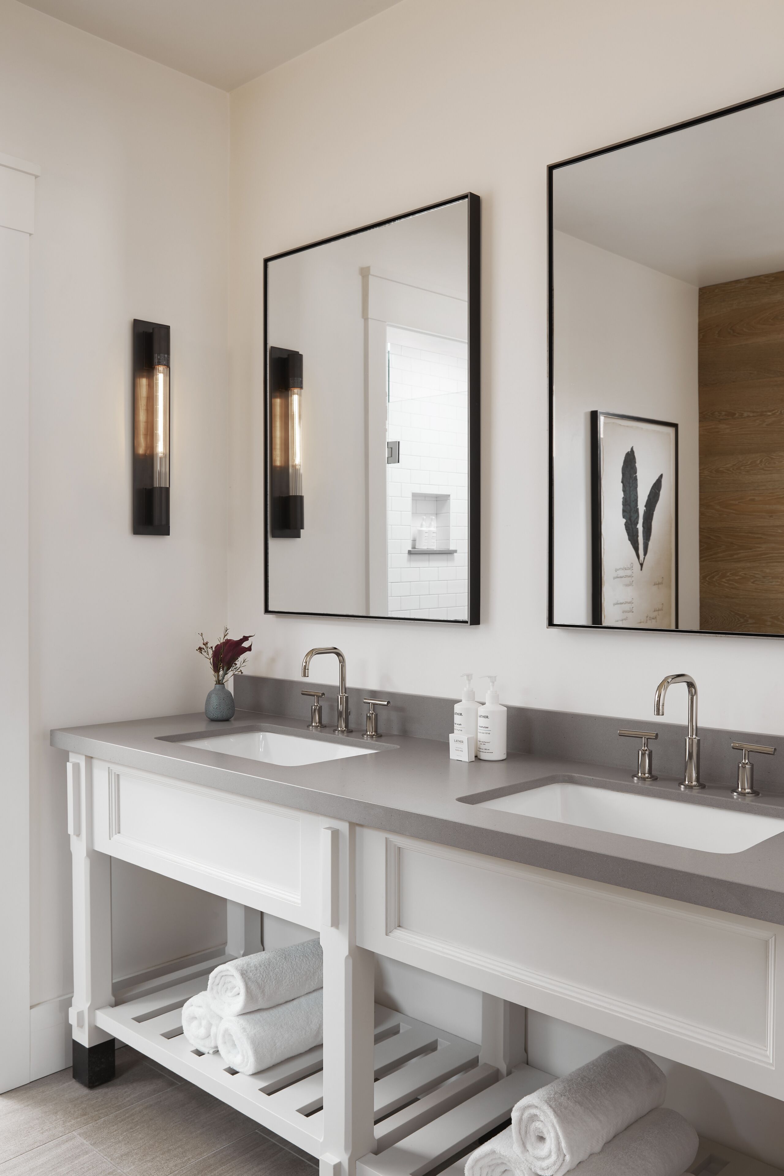 A modern bathroom with two sinks, a vanity, and a mirror.
