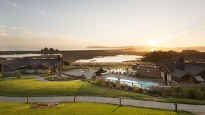 A residential area with a swimming pool, houses, and a view of the water body during sunset. - The Lodge at Bodega Bay (Bodega Bay)
