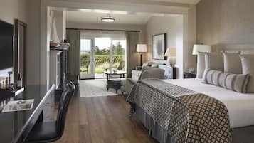A hotel room with a bed, a desk, a chair, a television, and a view of the outdoors.