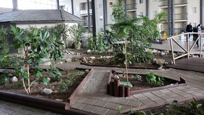 A spacious indoor garden with various plants and a brick pathway. - Coast Kamloops Hotel & Conference Centre (Kamloops)