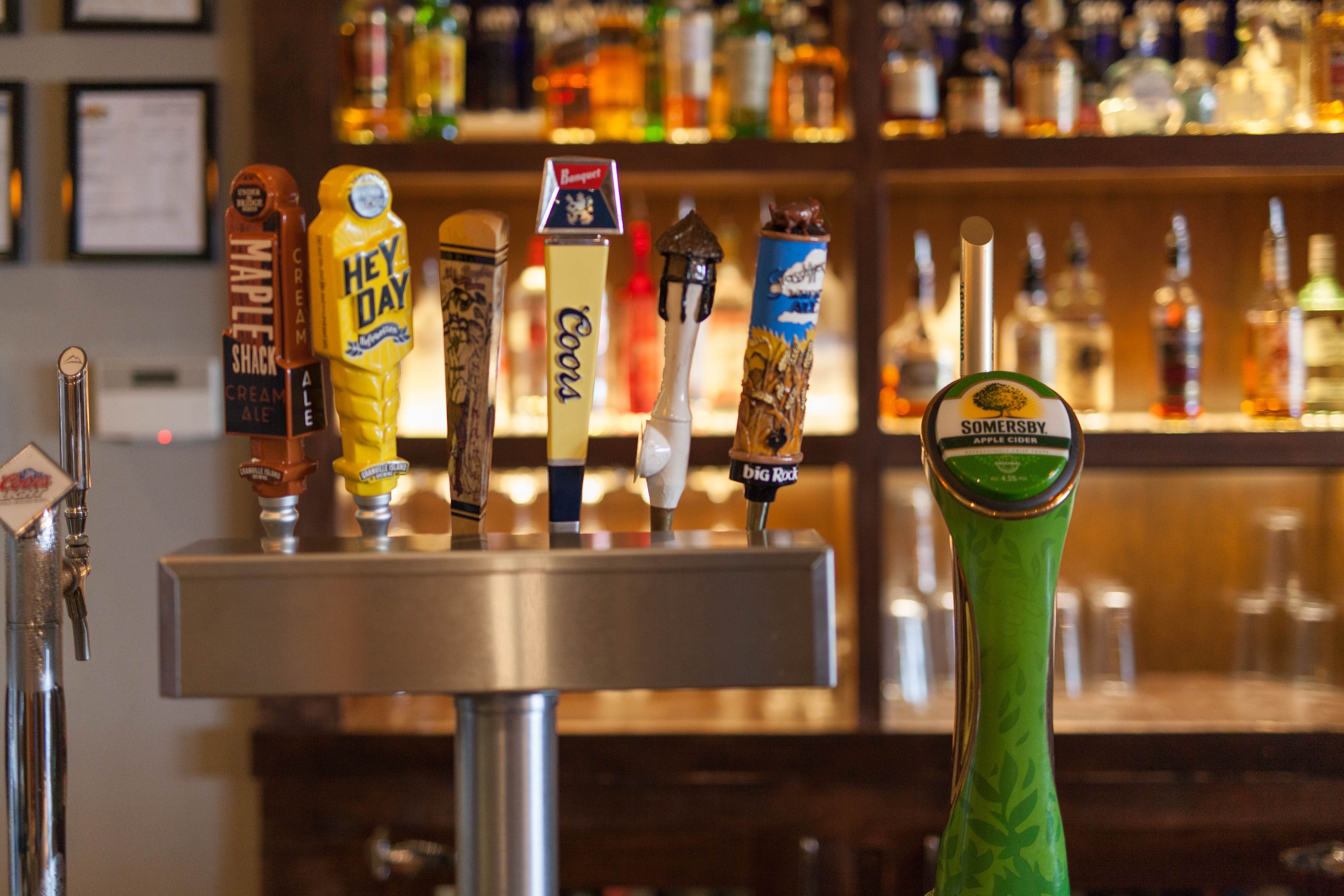 A bar with various beer taps and bottles in the background.