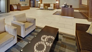 A spacious lobby with a reception desk, seating area, and a modern chandelier. - Coast Kamloops Hotel & Conference Centre (Kamloops)