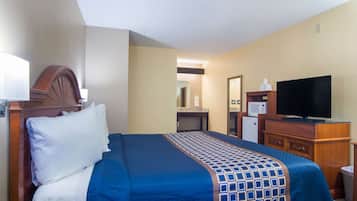 A hotel room with a bed, a television, a microwave, and a desk.