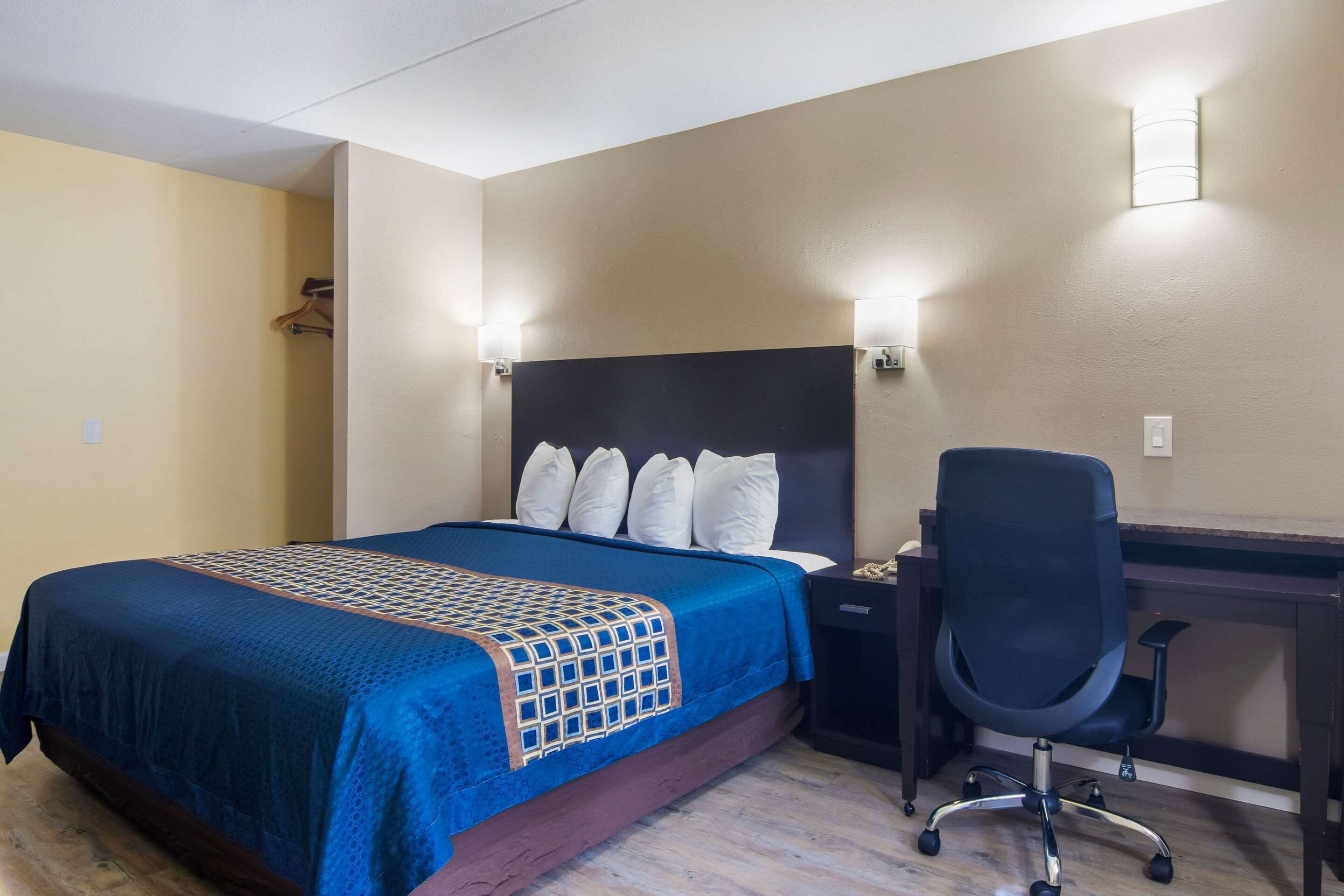 Ein Hotelzimmer mit Bett, Schreibtisch und Stuhl.