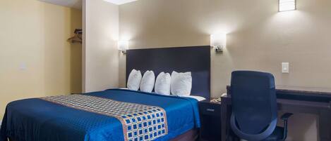 Ein Hotelzimmer mit Bett, Schreibtisch und Stuhl.