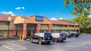 Un motel con un letrero que dice 'Rodeway Inn & Suites' y varios coches estacionados en el estacionamiento.
