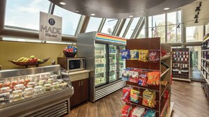 A food display area with a refrigerated section, a microwave, and a variety of packaged snacks. - DoubleTree by Hilton Hotel Orlando Downtown (Orlando)