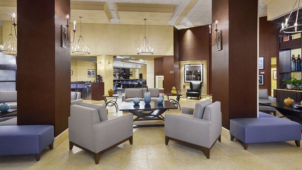 A spacious lobby with a central seating area, a bar, and a well-lit ceiling with chandeliers. - DoubleTree by Hilton Hotel Orlando Downtown (Orlando)