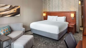 Een hotelkamer met een groot bed, een bank, een tafeltje en een bureau.