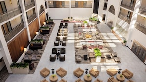 A spacious indoor courtyard with multiple seating areas, including sofas and chairs, arranged around a central table. - Embassy Suites by Hilton Cincinnati Northeast Blue Ash (Cincinnati)