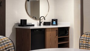 A modern bathroom with a round mirror, black faucet, coffee machine, and built-in dishwasher. - Embassy Suites by Hilton Cincinnati Northeast Blue Ash (Cincinnati)