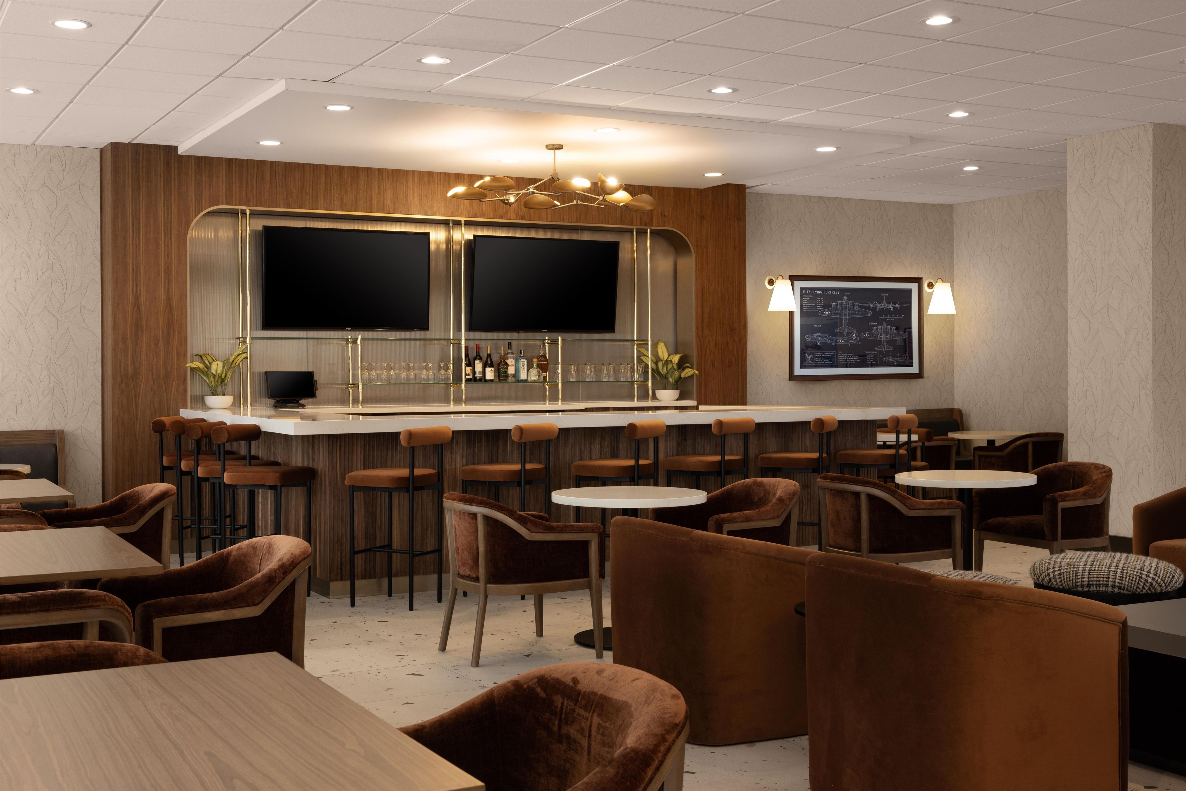 A bar area with multiple stools, a counter, and a television screen.