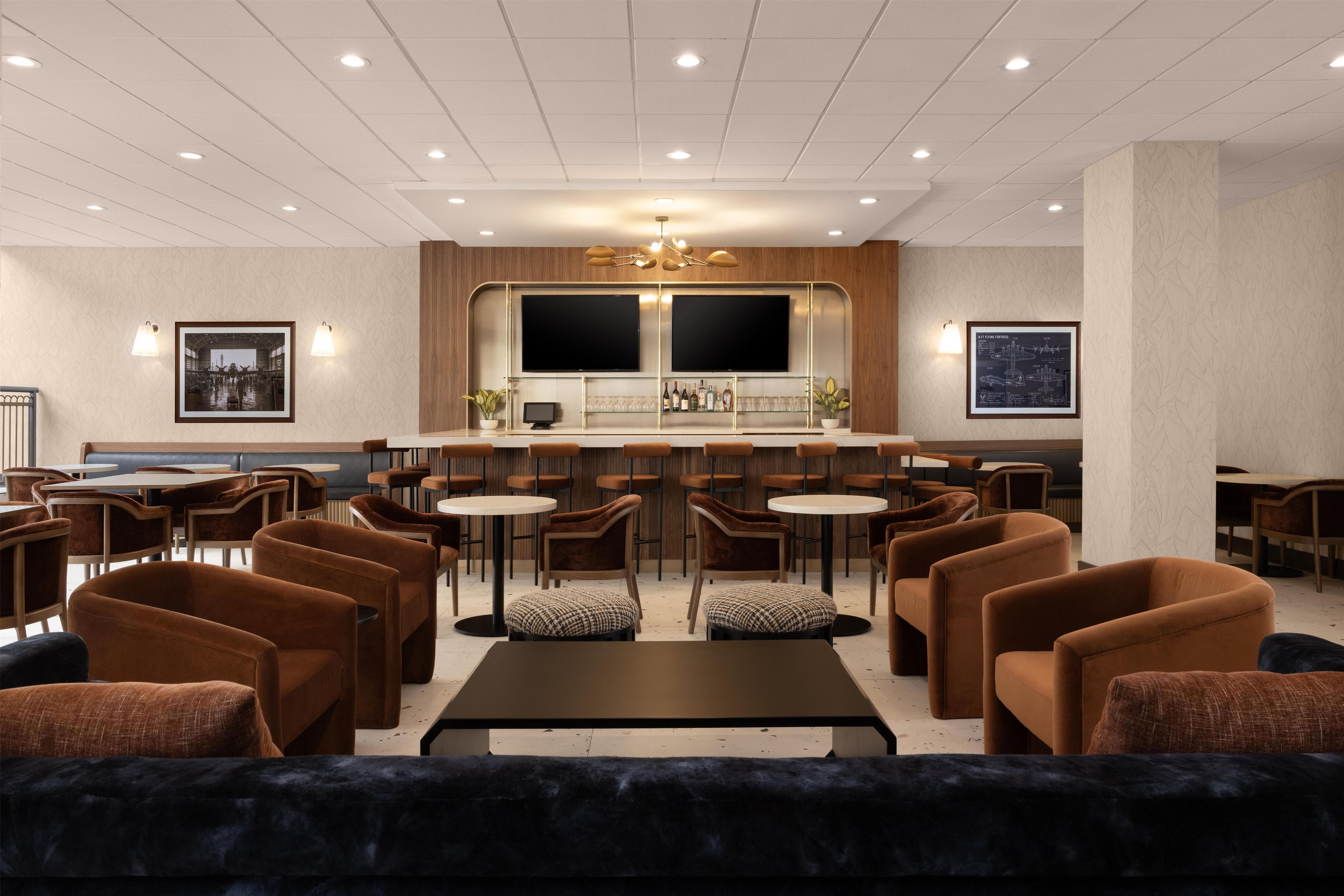 A modern bar area with a large flat-screen TV, bar counter, and seating arrangement.