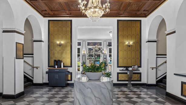 A lobby with a marble column, a chandelier, and a checkered floor. - Inn At The Park (San Diego)