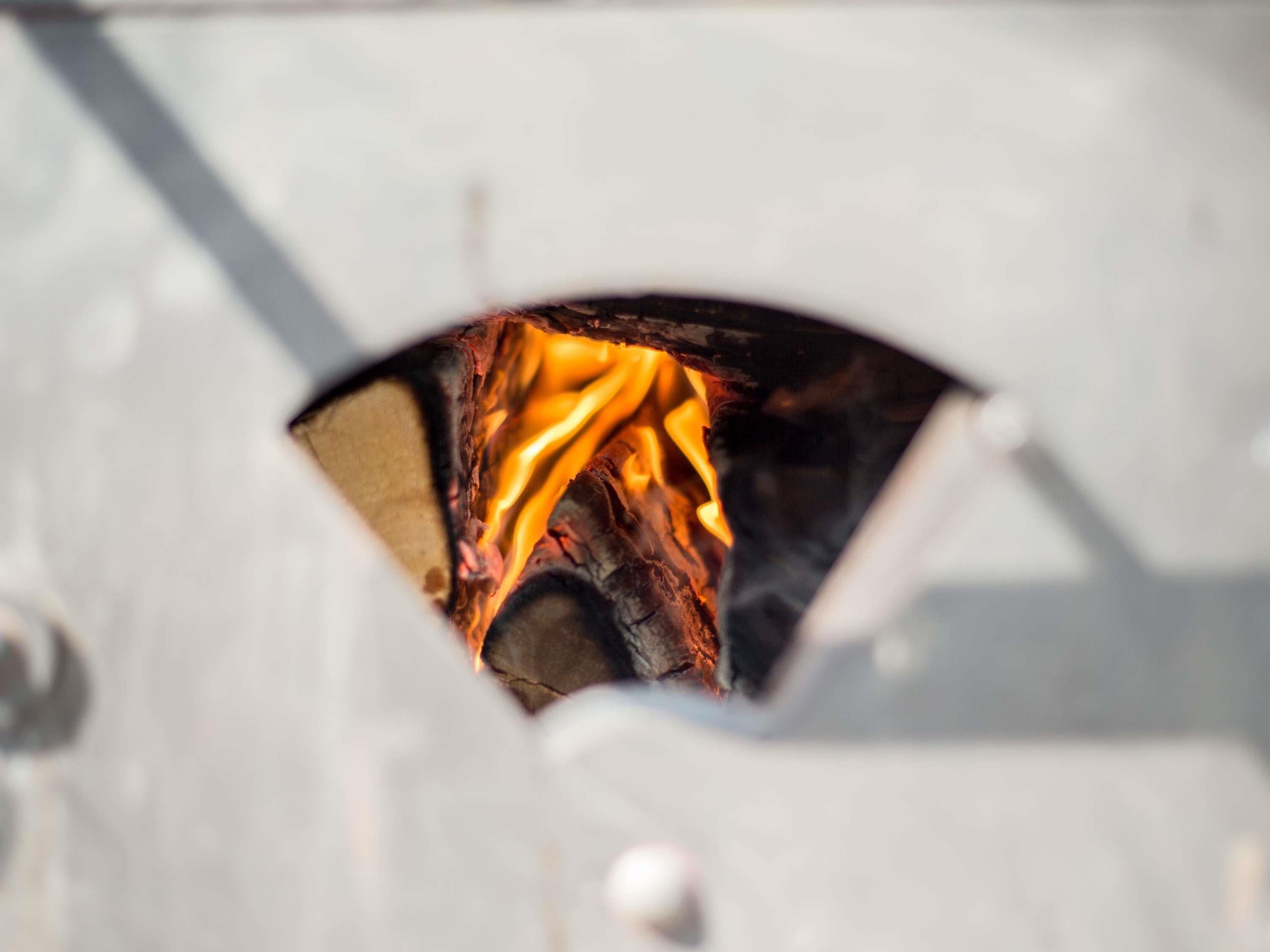 Primer plano de un fuego ardiendo dentro de una estructura metálica.