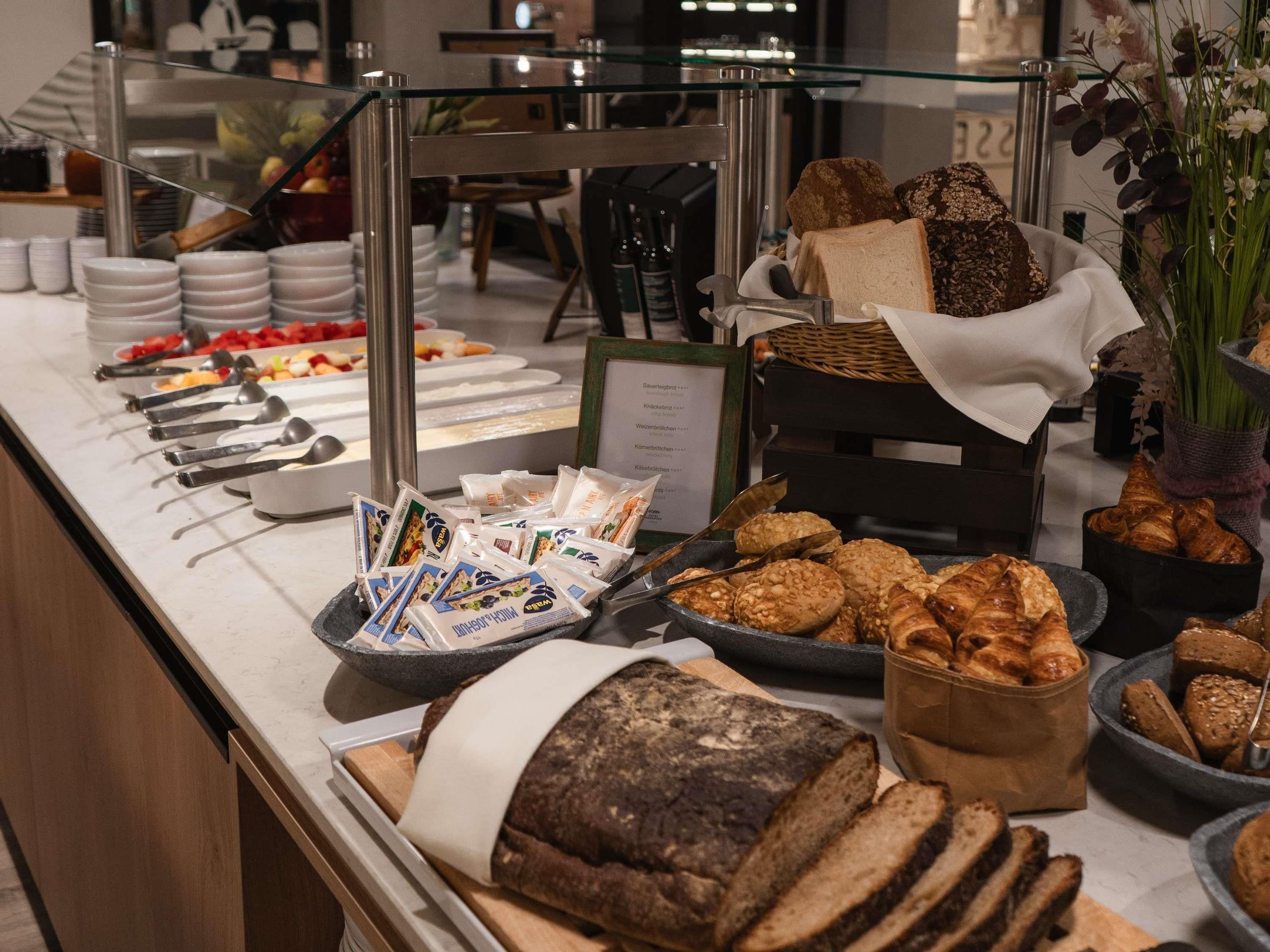 Un bufé con panes, pasteles y salsas diversas.