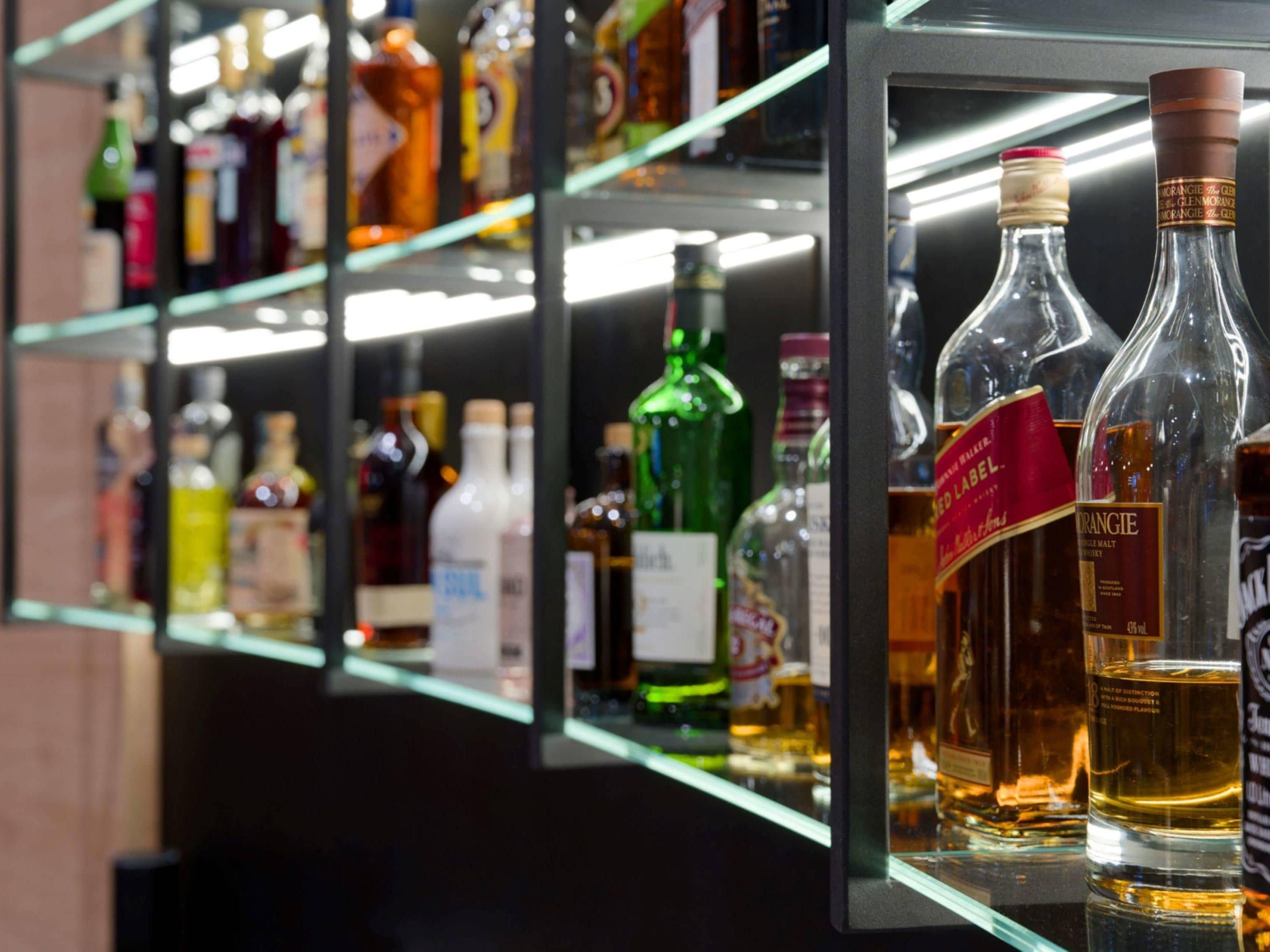 Un bar con estantes llenos de diferentes botellas de licores.