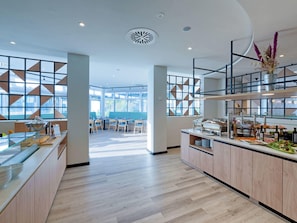 A modern hotel lobby with a central bar area, seating arrangements, and large windows. - Fora Hotel Hannover by Mercure (Hannover)