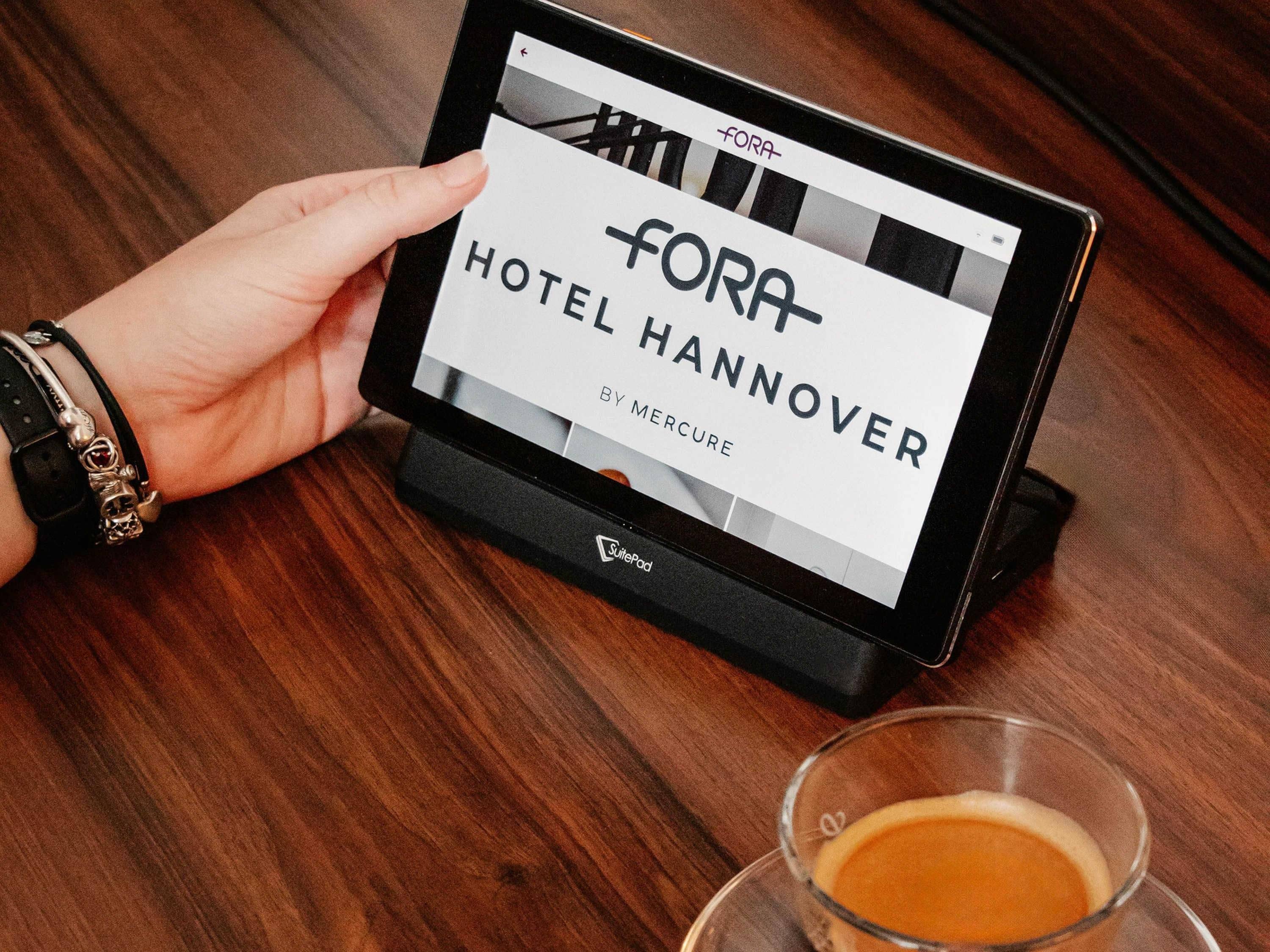 A tablet displaying a hotel booking interface for FORA HOTEL HANNOVER by MERCURE.
