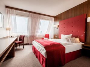 A hotel room with a large bed, a desk, a chair, and a window with curtains. - Fora Hotel Hannover by Mercure (Hannover)