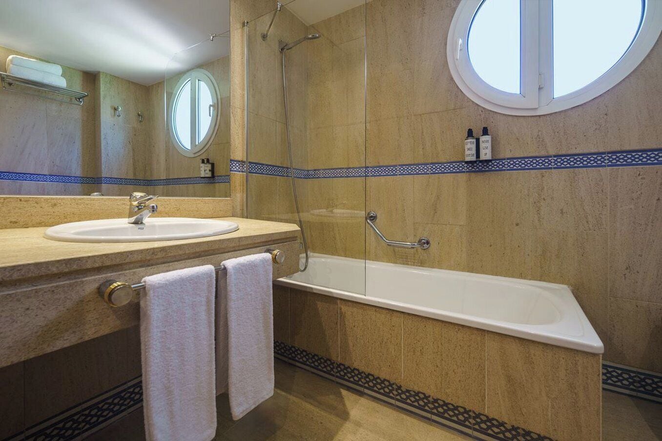 Un baño con lavabo, espejo y bañera.