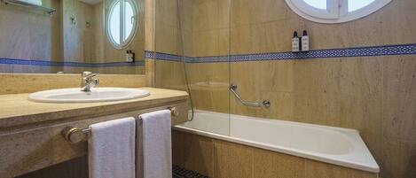 Un baño con lavabo, espejo y bañera.