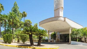 Un edificio moderno con techo curvo y una torre cilíndrica alta.