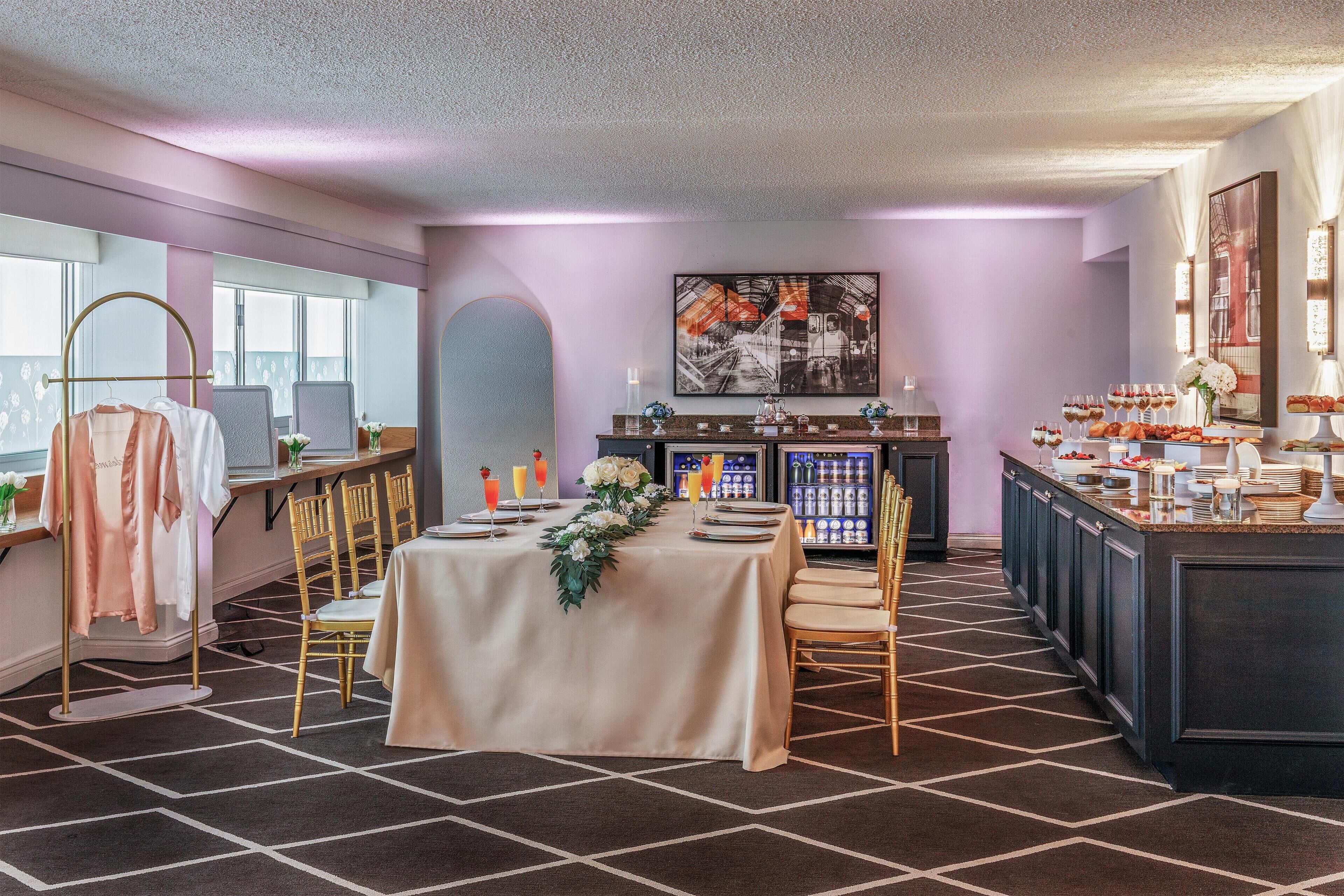 Een hotelkamer met een eethoek, een bar en een koelkastje.