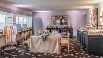 Een hotelkamer met een eethoek, een bar en een koelkastje.