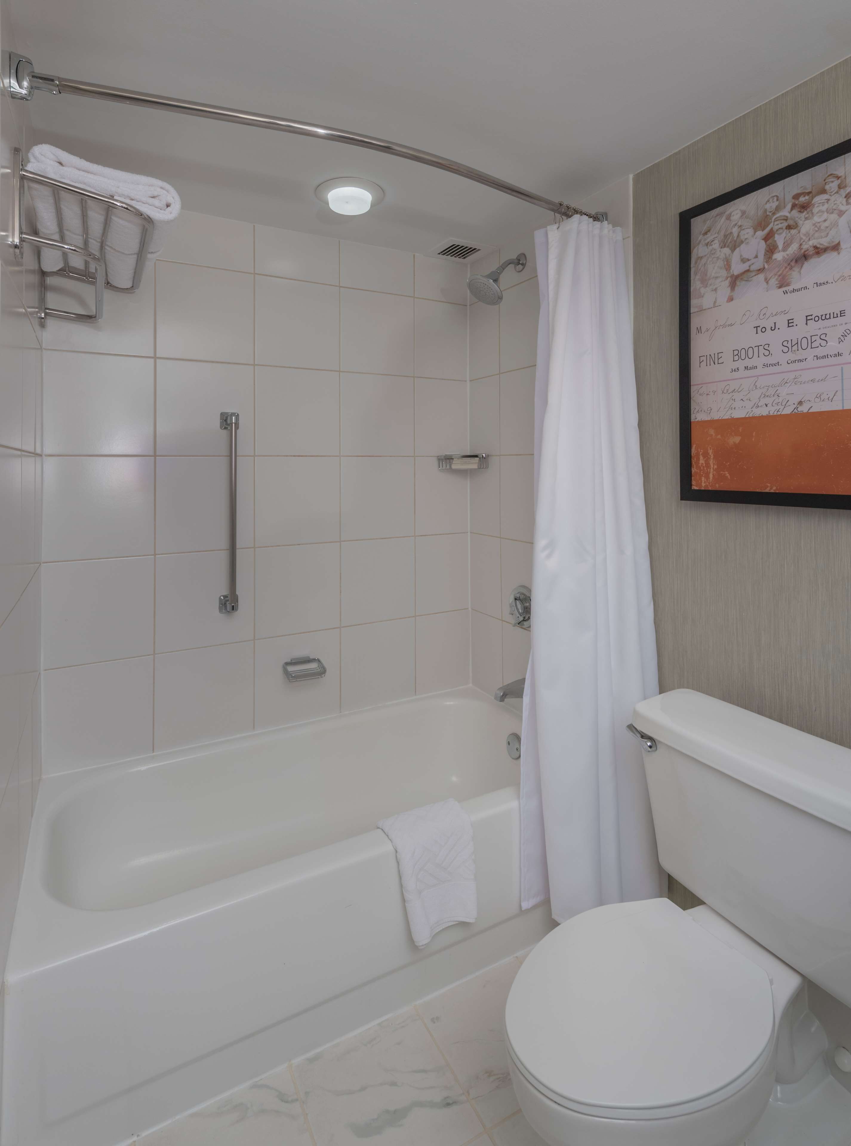 A bathroom with a bathtub, toilet, and shower area.