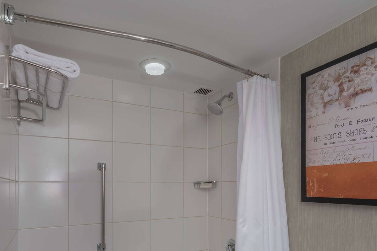 A bathroom with a bathtub, toilet, and shower area.