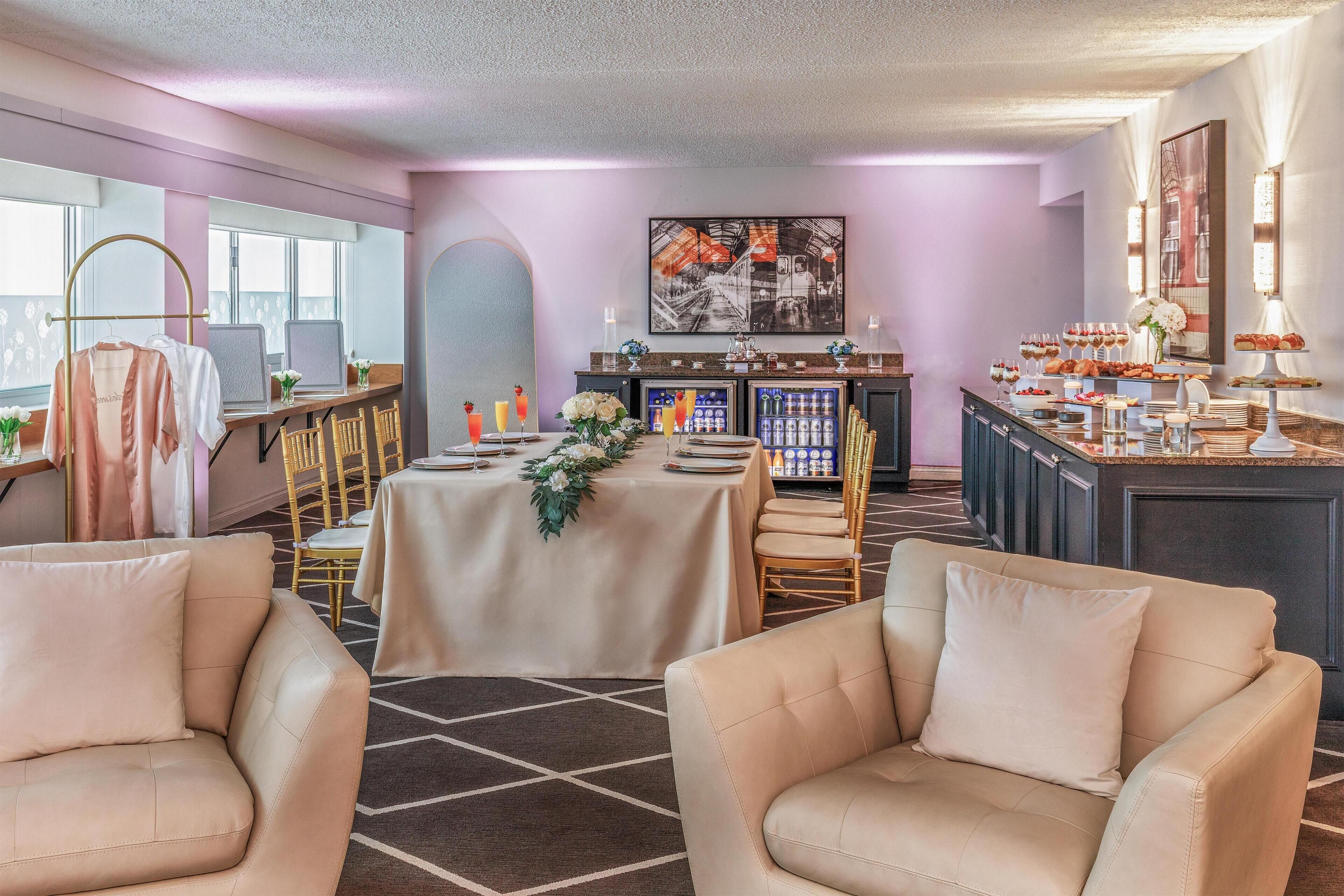 A hotel room with a dining area, a bar, and a seating area with two sofas.