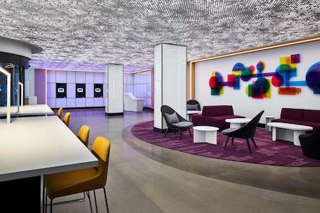 A modern interior with a reception desk, seating area, and a colorful abstract wall art.