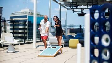 Une terrasse avec des sièges extérieurs et une table de jeu de palet.
