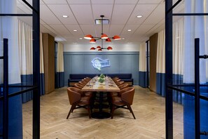 A conference room with a long table, chairs, a neon light, and a ceiling with recessed lighting. - YOTEL Washington DC, Select by Hilton (Washington)